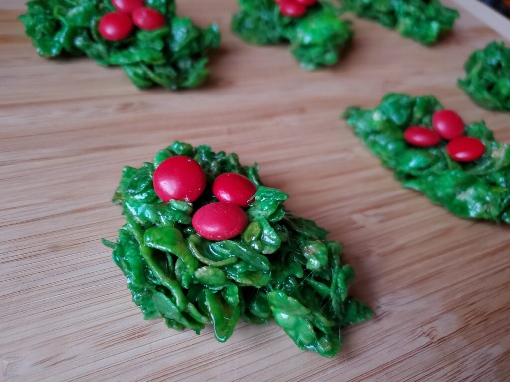 Classic holly wreath cookies on a wooden board.