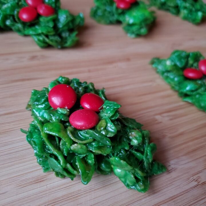 Classic holly wreath cookies on a wooden board.