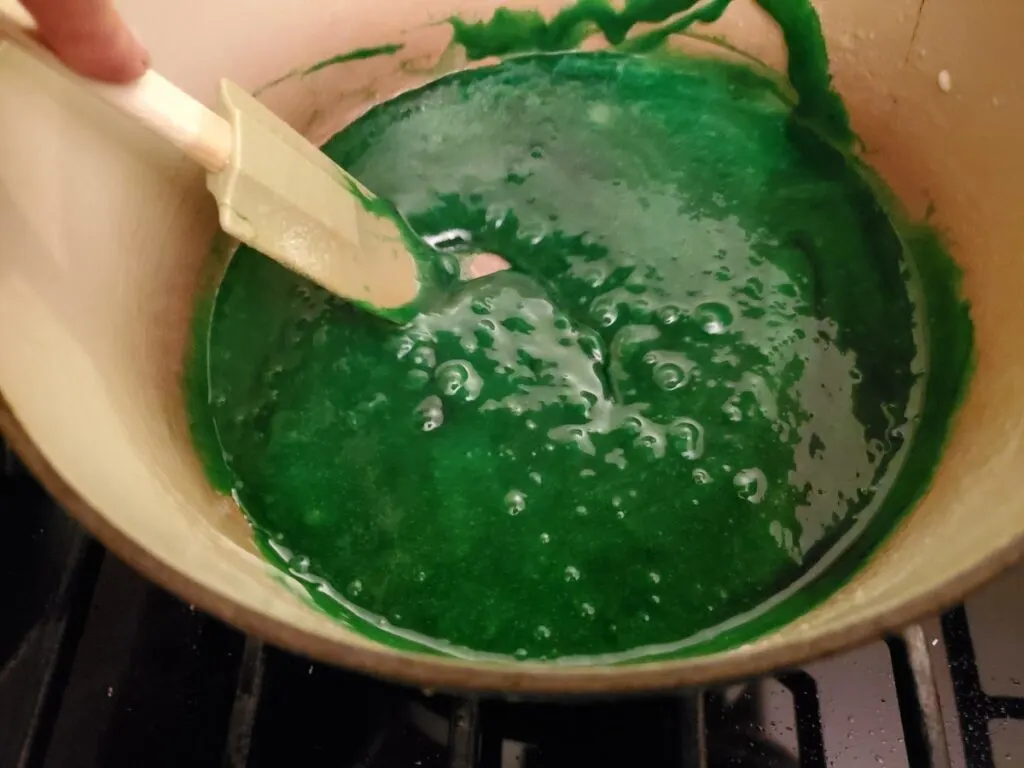 Green melted marshmallows in a pot.