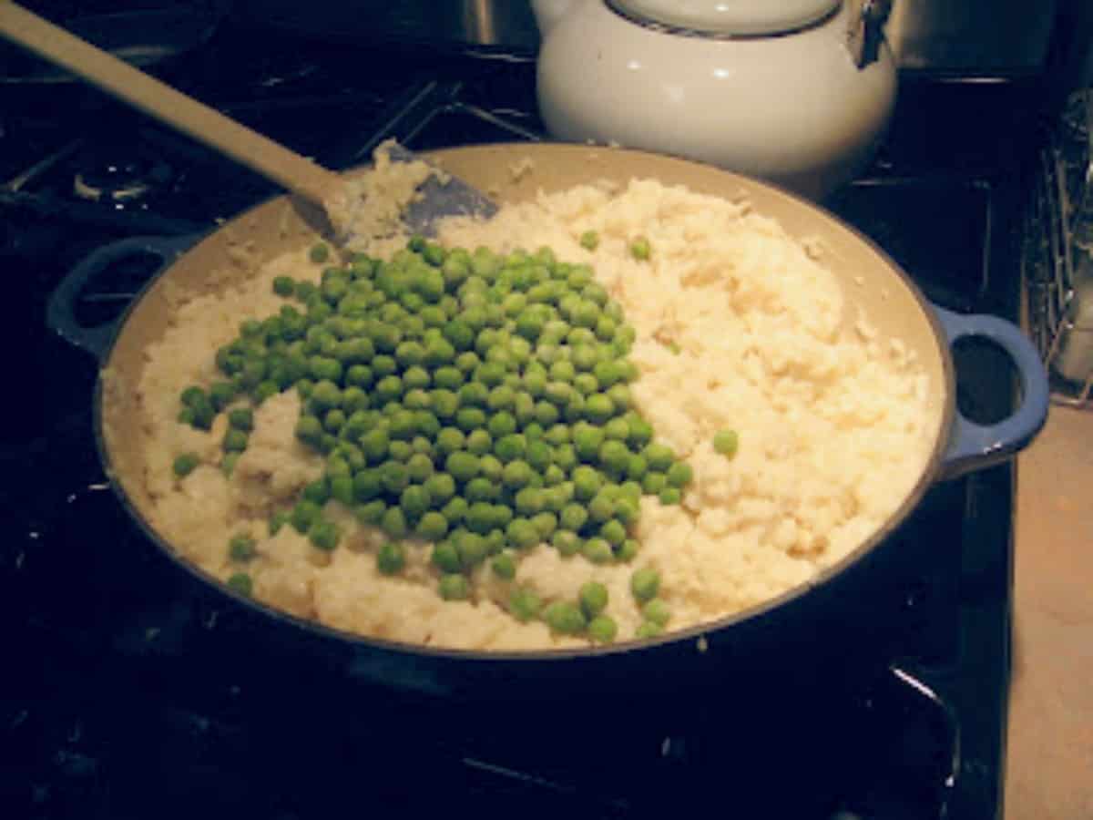Frozen peas on top of a chicken and rice fake risotto.