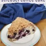 Coffee cake on a plate with blue background.