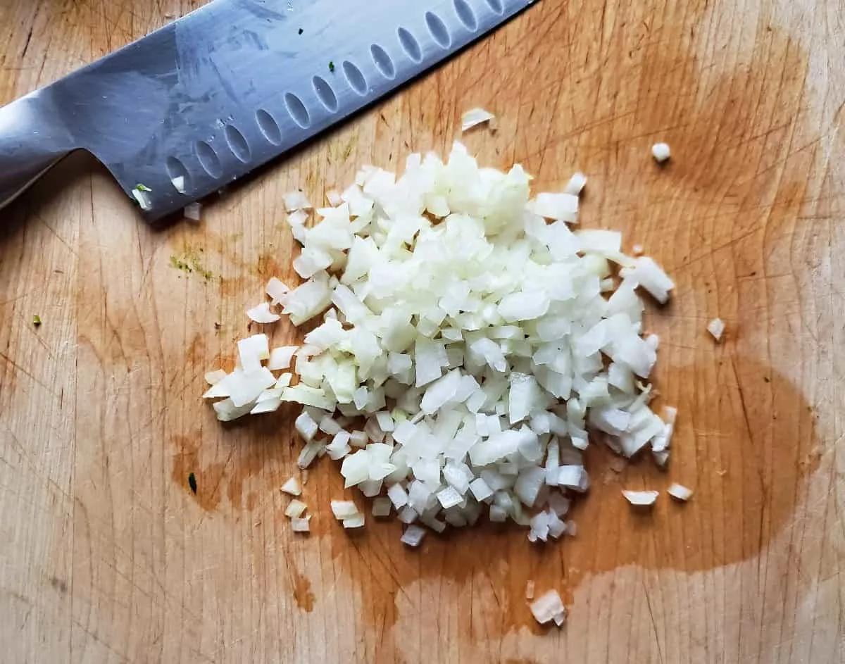 Diced onion on a wooden cutting board.