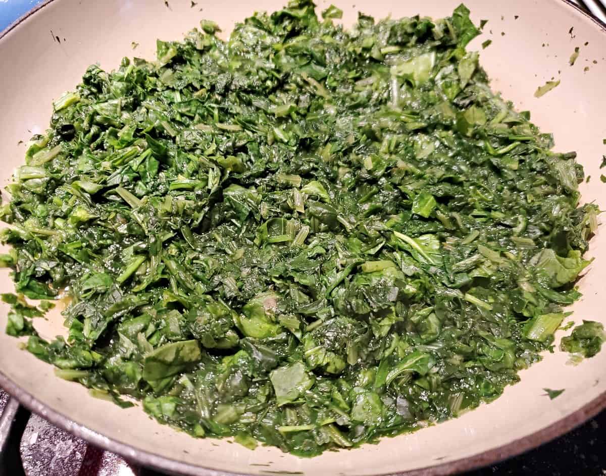 Sauted and chopped spinach in a shallow pan.