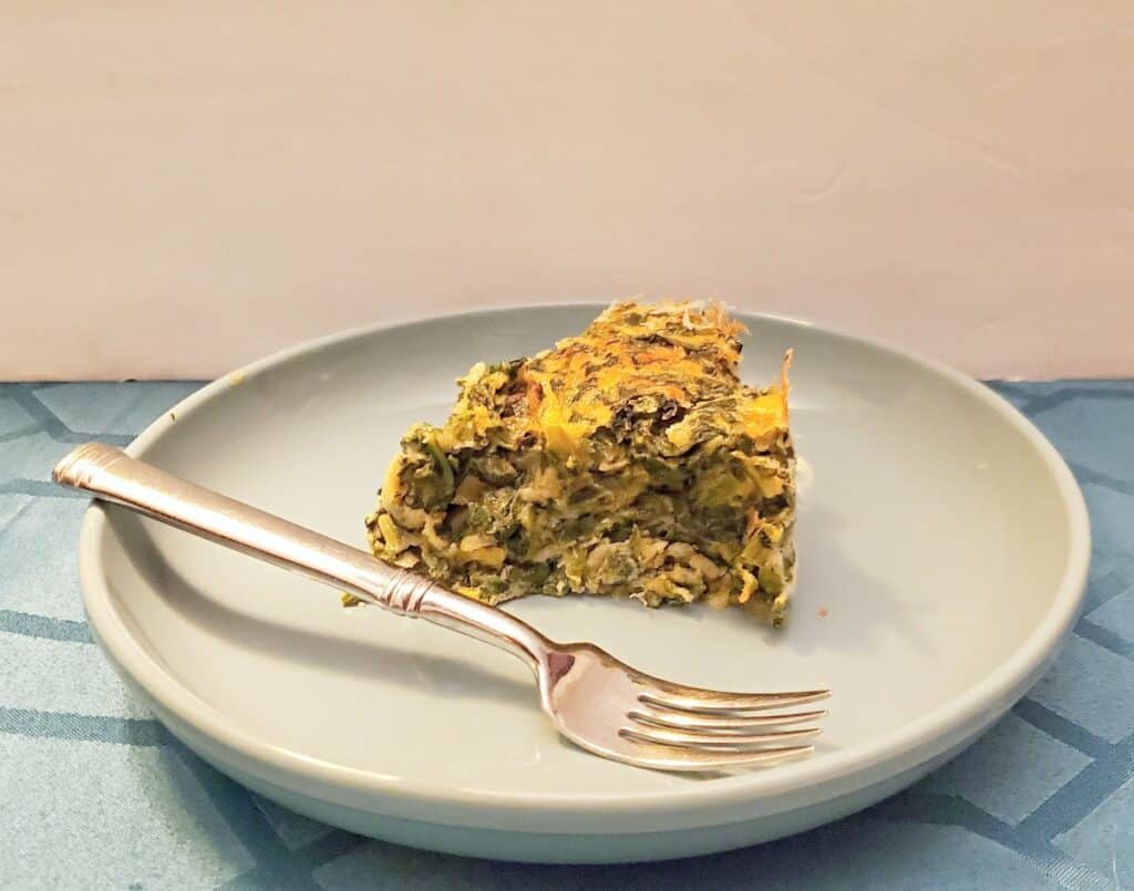 Slice of spinach souffle on a blue plate.