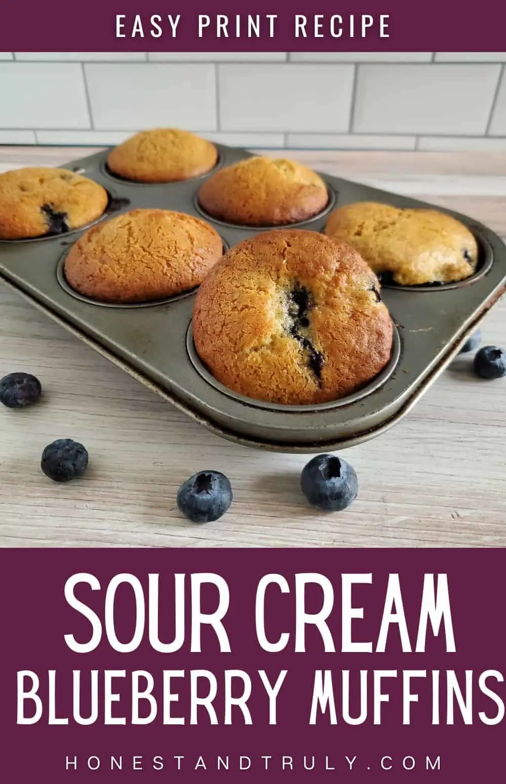 Blueberry muffins in a tin with text sour cream blueberry muffins.