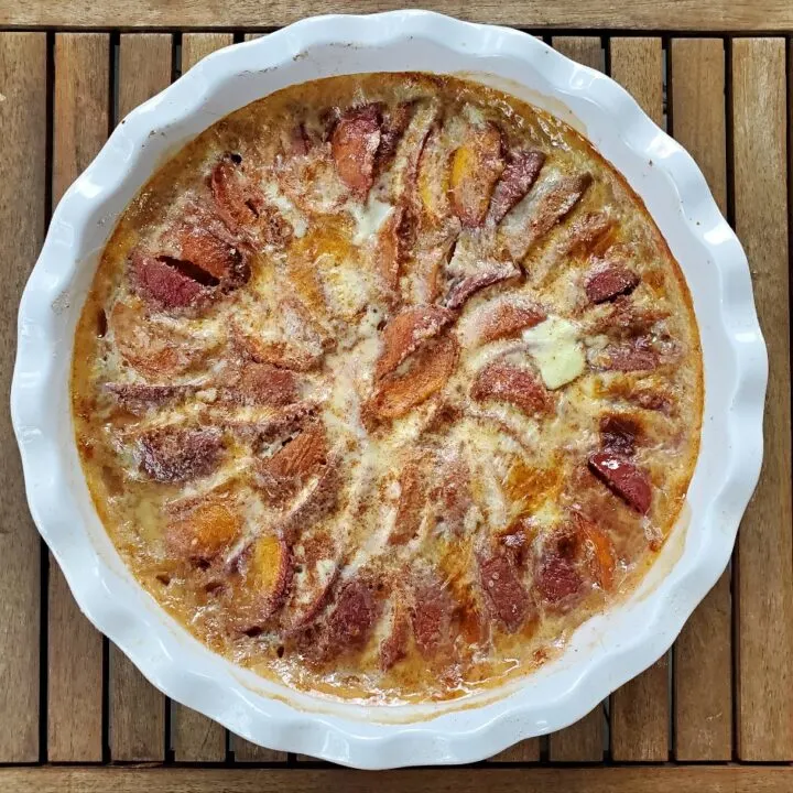 Overhead shot of a baked peach kuchen in a pie pan.