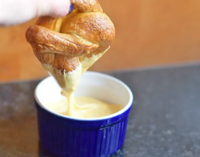 Dip homemade pretzel in cheese sauce