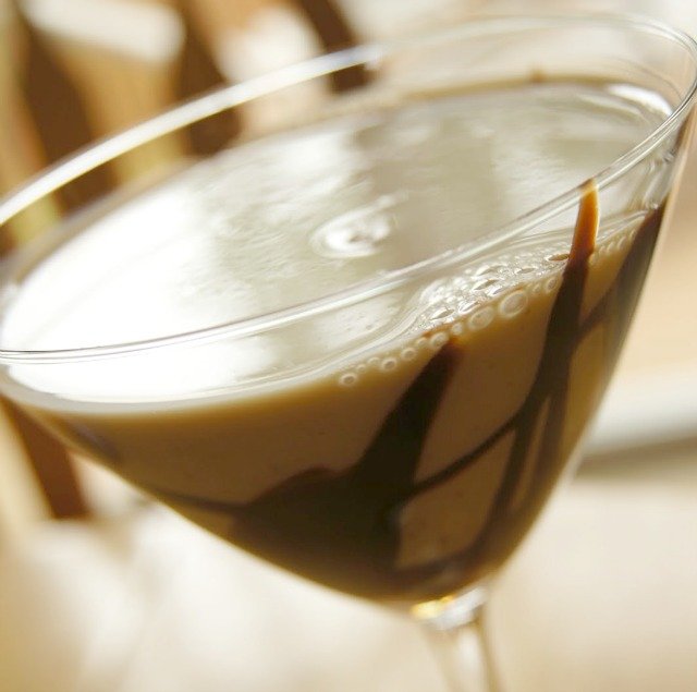 Image shows a chocolate martini in a glass tilted to the side.