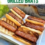Grilled brats in toasted buns by a grill