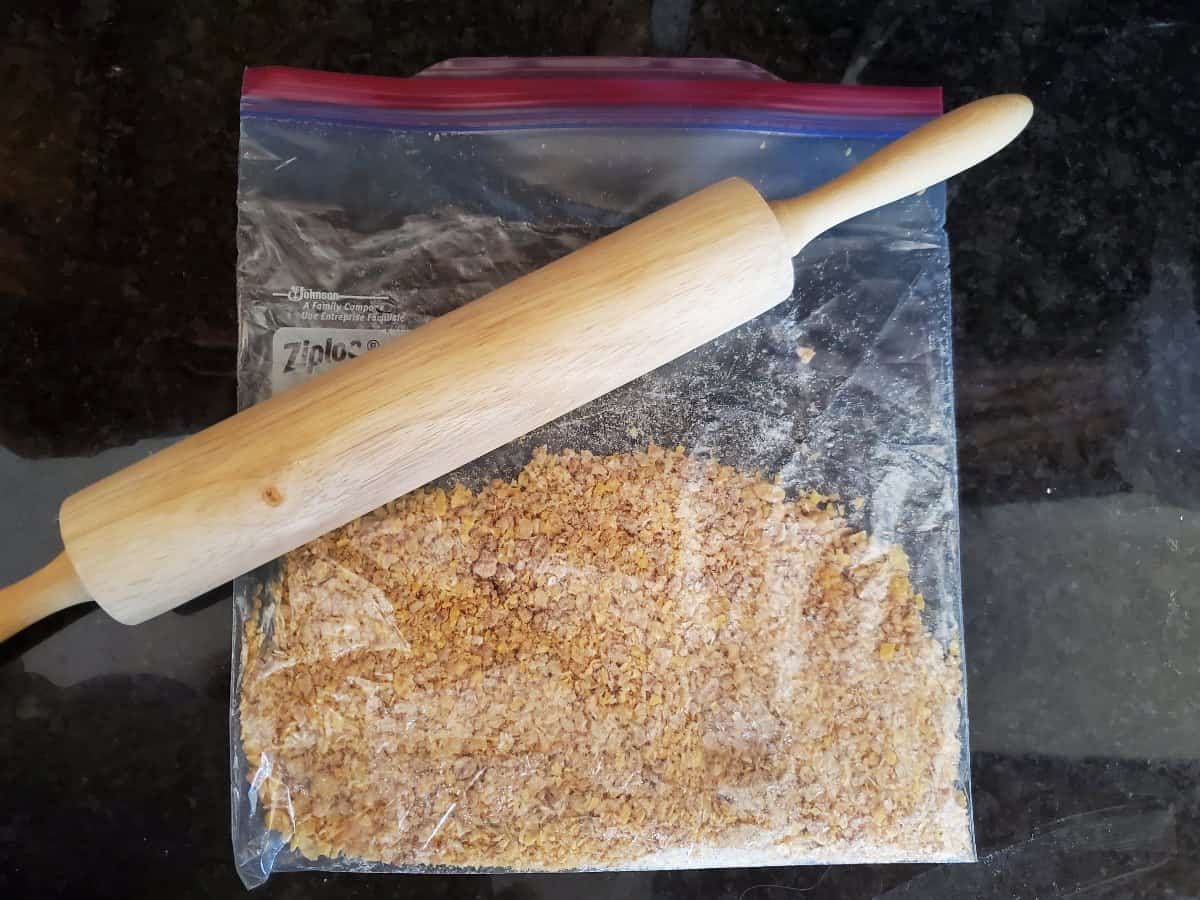 Crushed cereal in a baggie with a rolling pin on the bag.