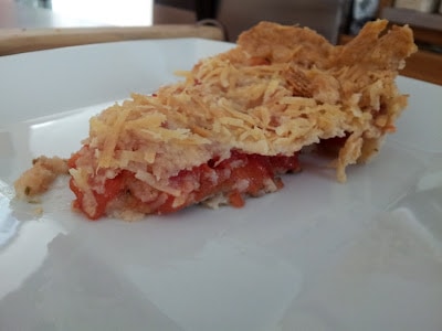 Slice of tomato tart sitting on a white plate.
