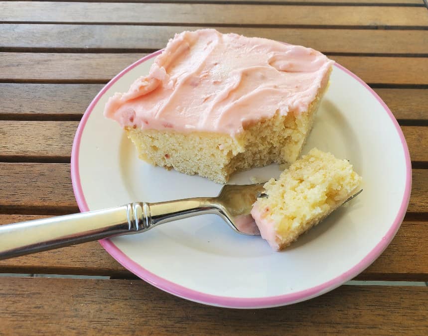 Slice of yellow cake with strawberry frosting