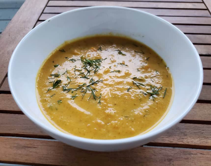 Delicious bowl of carrot ginger soup with dill on top