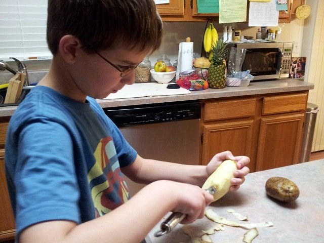 Mister Man peeling potatoes for mashed potatoes