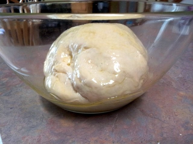 Dough is coated in oil in the bowl
