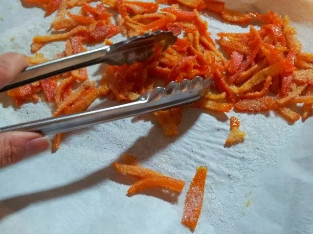 Use tongs to help toss the candied citrus peels in sugar to avoid getting your hands messy