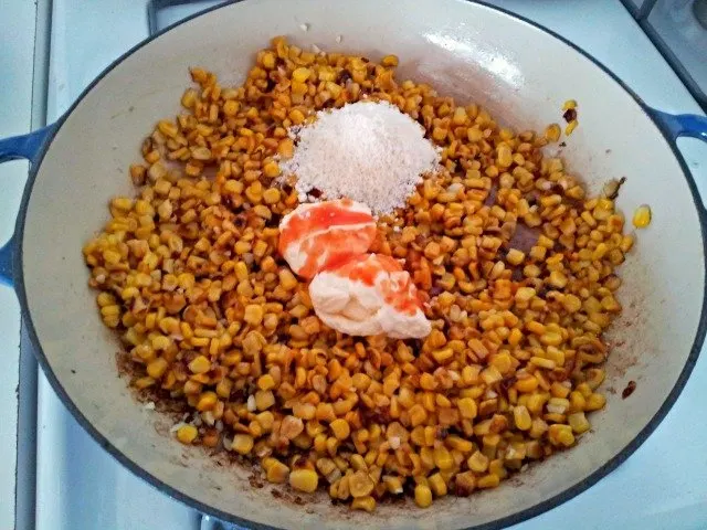 Add ingredients for elotes directly to the pan once the corn is roasted