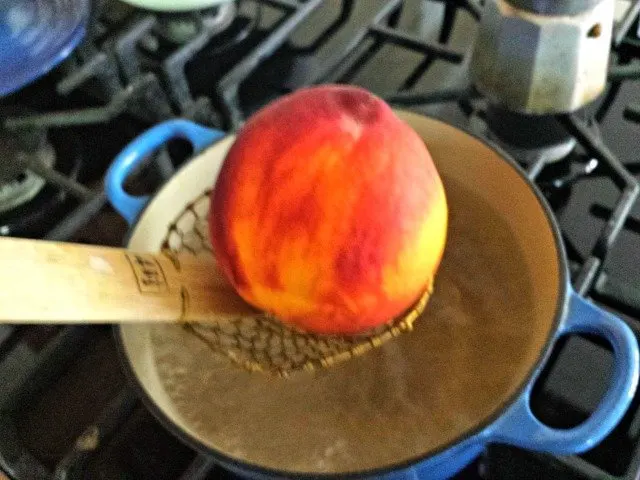 Lower peach carefully into boiling water