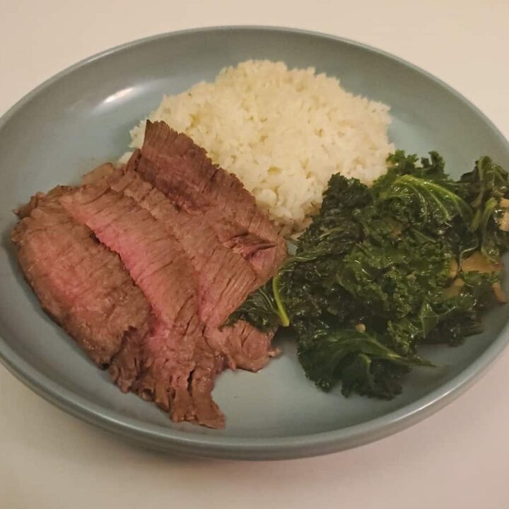 Asian marinated steak dinner on a blue plate.