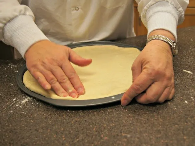 Patting your pizza crust into place