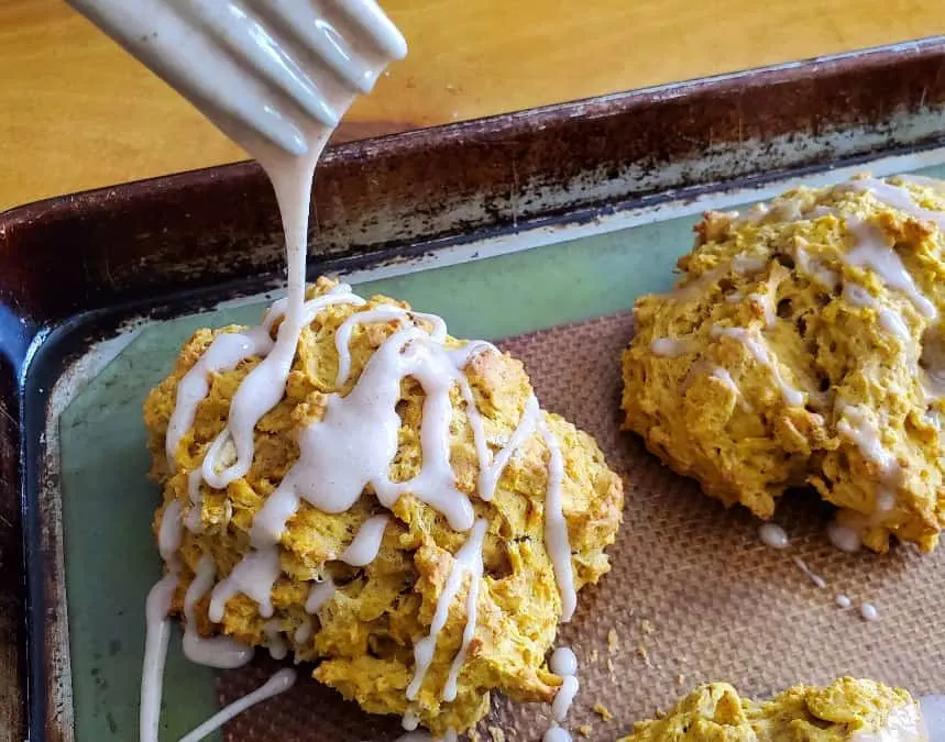 Drizzling glaze onto a pumpkin scone