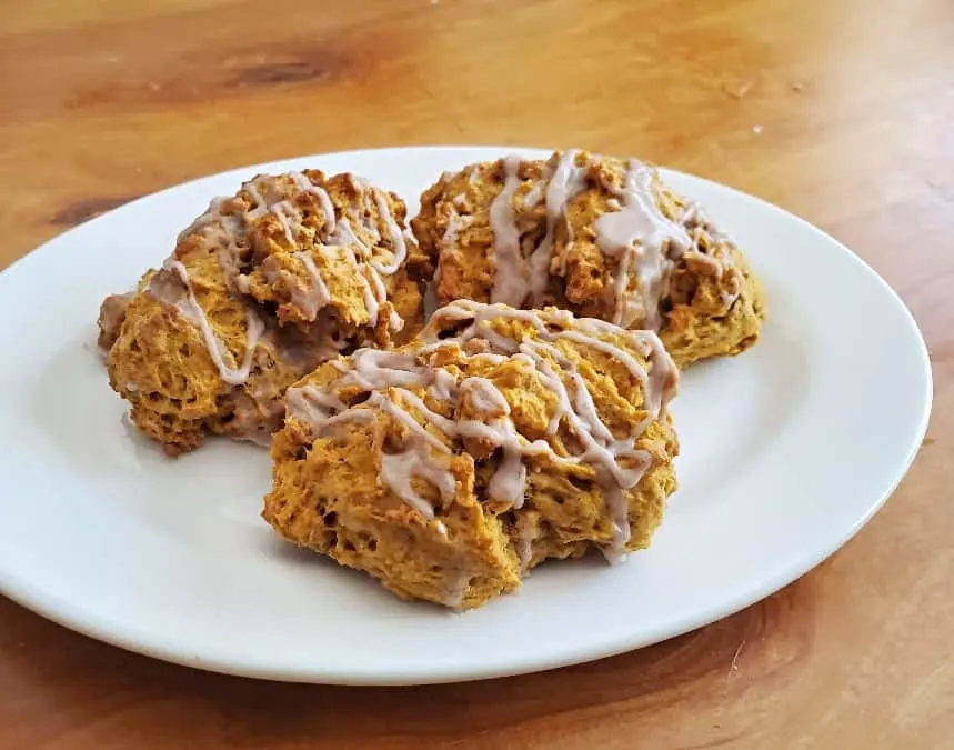 Three pumpkin scones on a white plate