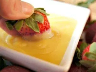 Dipping strawberries in pineapple curd