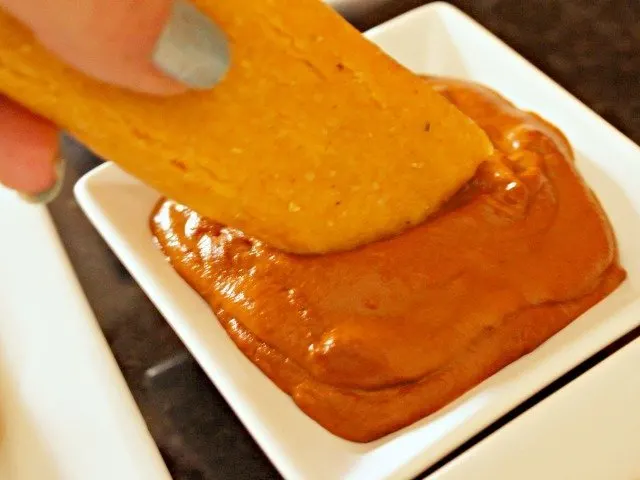 Dipping tamale in mole