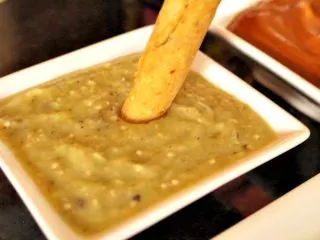 Dipping taquitos in roasted tomatillo salsa