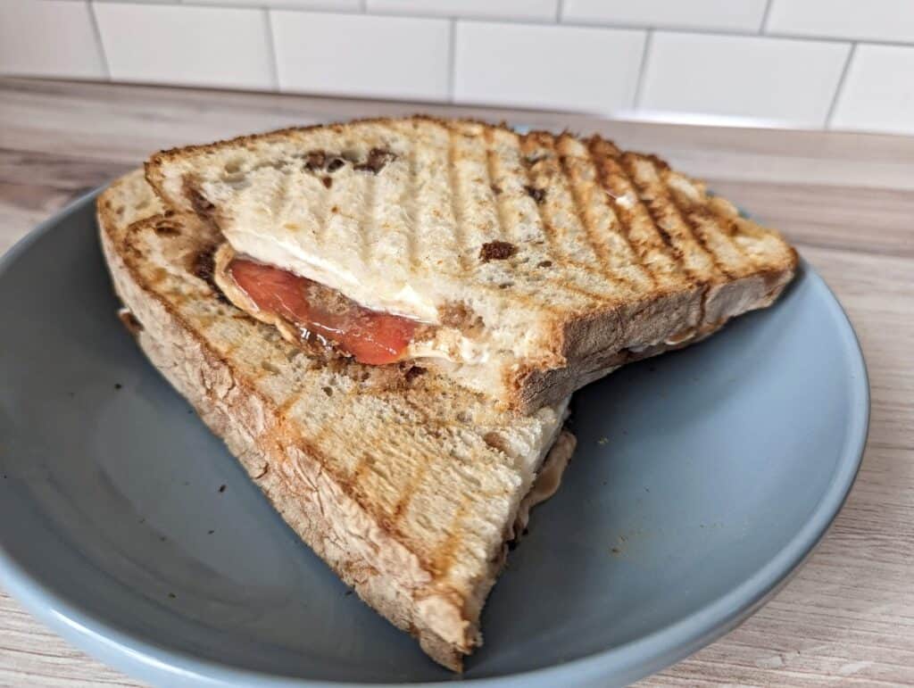 Grilled Caprese panini sandwich on a blue plate.
