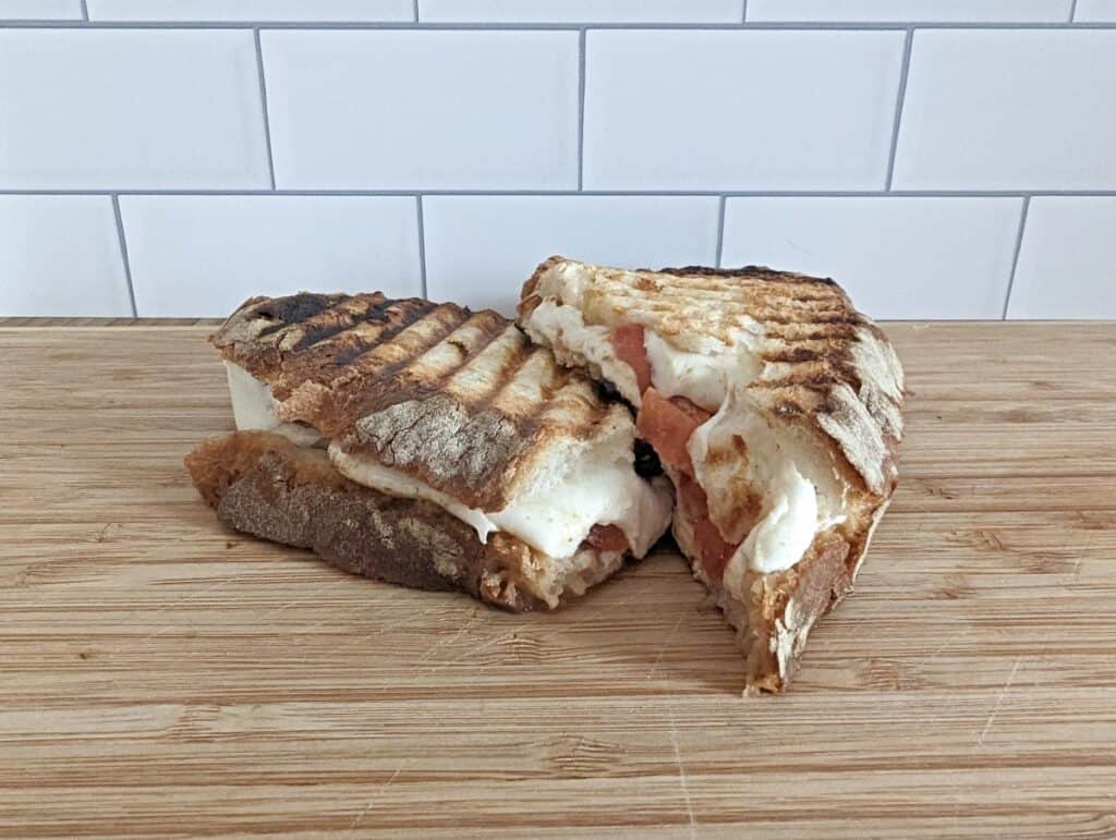 Image of a sliced mozzarella tomato panini stacked on itself.