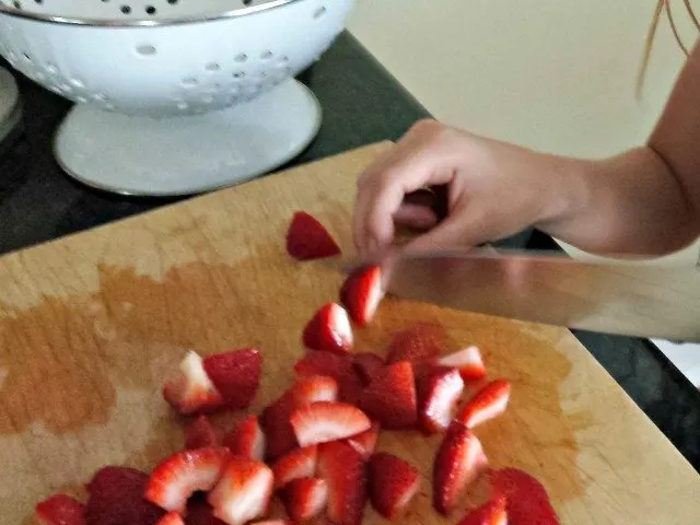 Cutting strawberries for homemade strawberry muffins