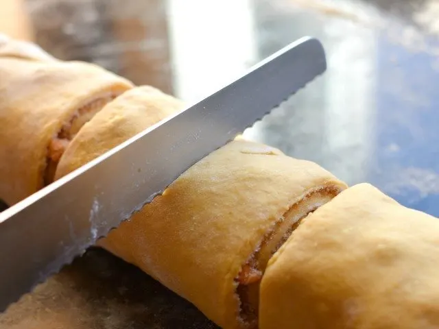 Slice cinnamon rolls with a bread knife