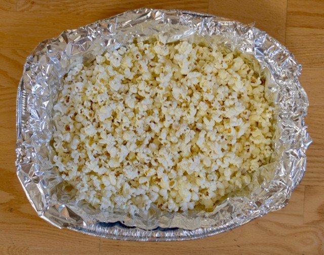 Add popcorn to foil lined baking dish
