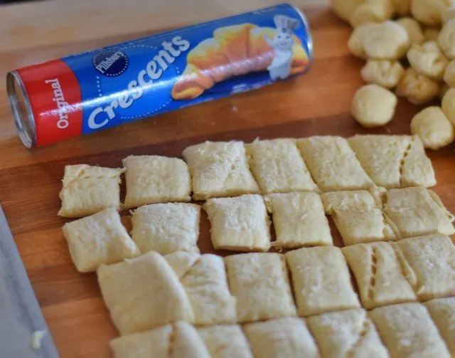Cut crescent roll dough into squares then roll