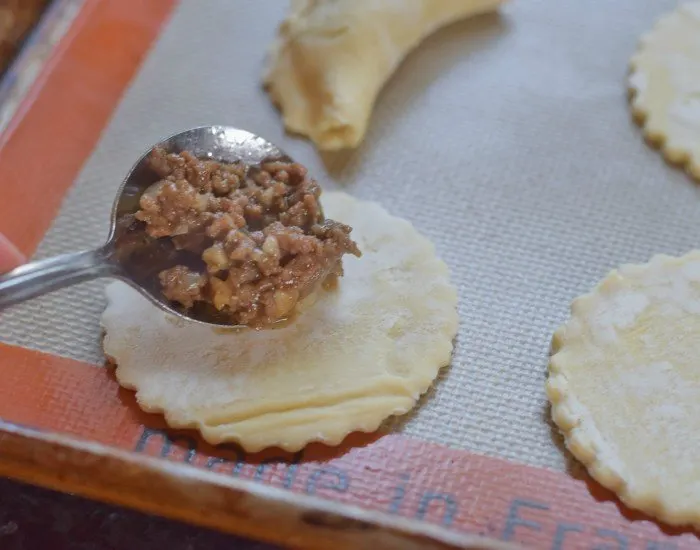 Add a bare teaspoon just off center of your empanada round