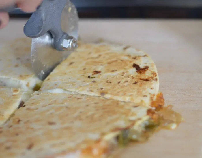 Use pizza cutter to slice carnitas stuffed quesadillas