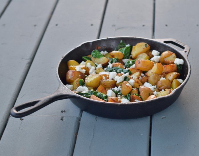 Skillet of oven roasted potatoes with spinach
