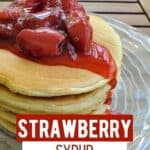 Side of a stack of pancakes with strawberry syrup