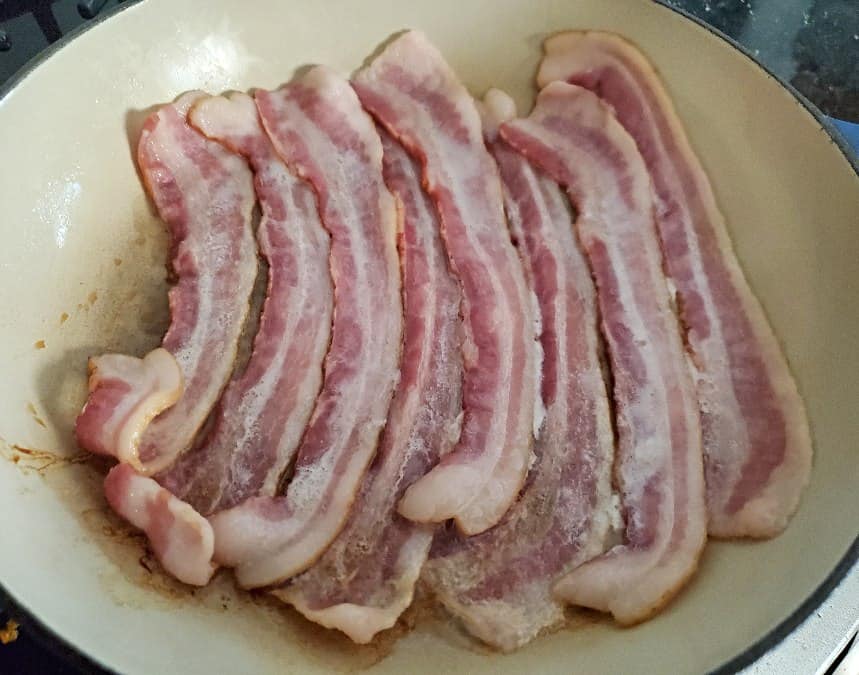 Bacon in a skillet to cook