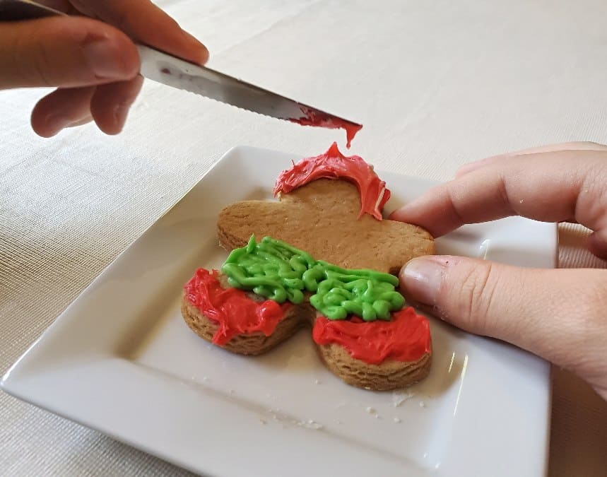 Blending icing colors with a knife for gingerbread man