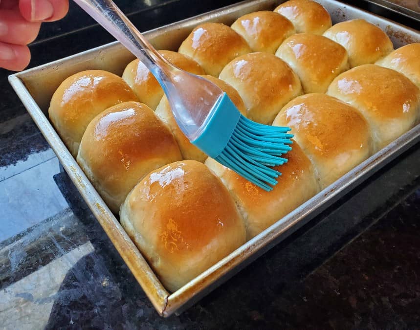 Brushing butter on just baked yeast rolls