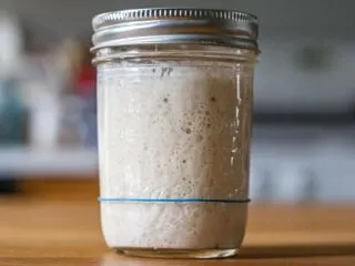 Bubbly sourdough starter in a mason jar on a counter
