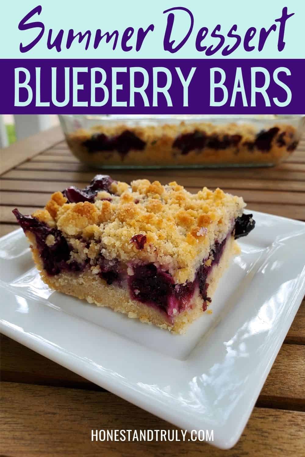 Blueberry streusel bars on a plate on a wooden table outside.