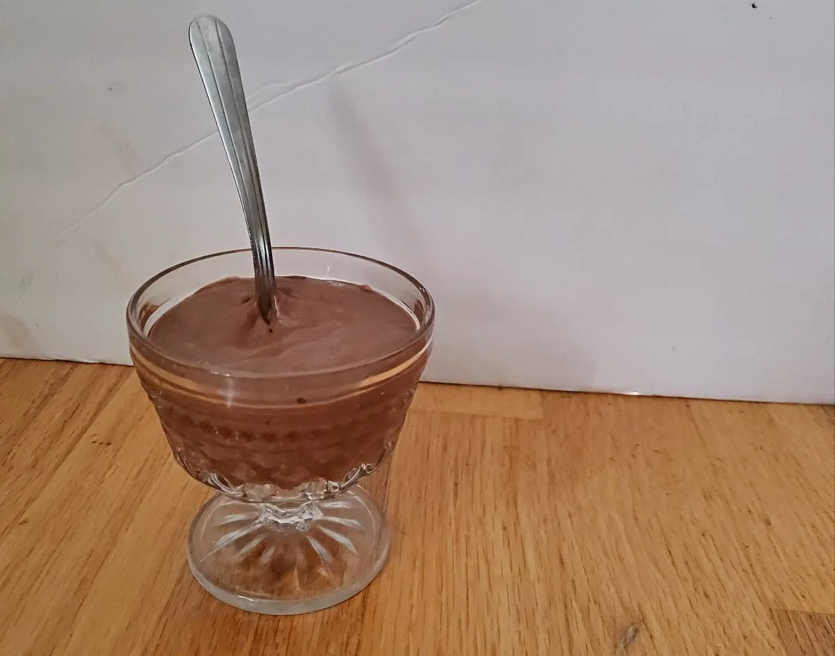 Bourbon chocolate mousse in a glass dish with a spoon.