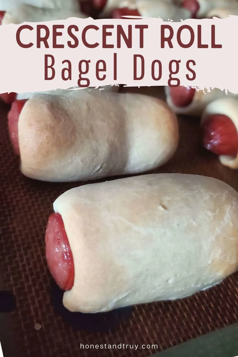 Crescent roll dogs close up on a diagonal sitting on a silpat with text of crescent roll bagel dogs.