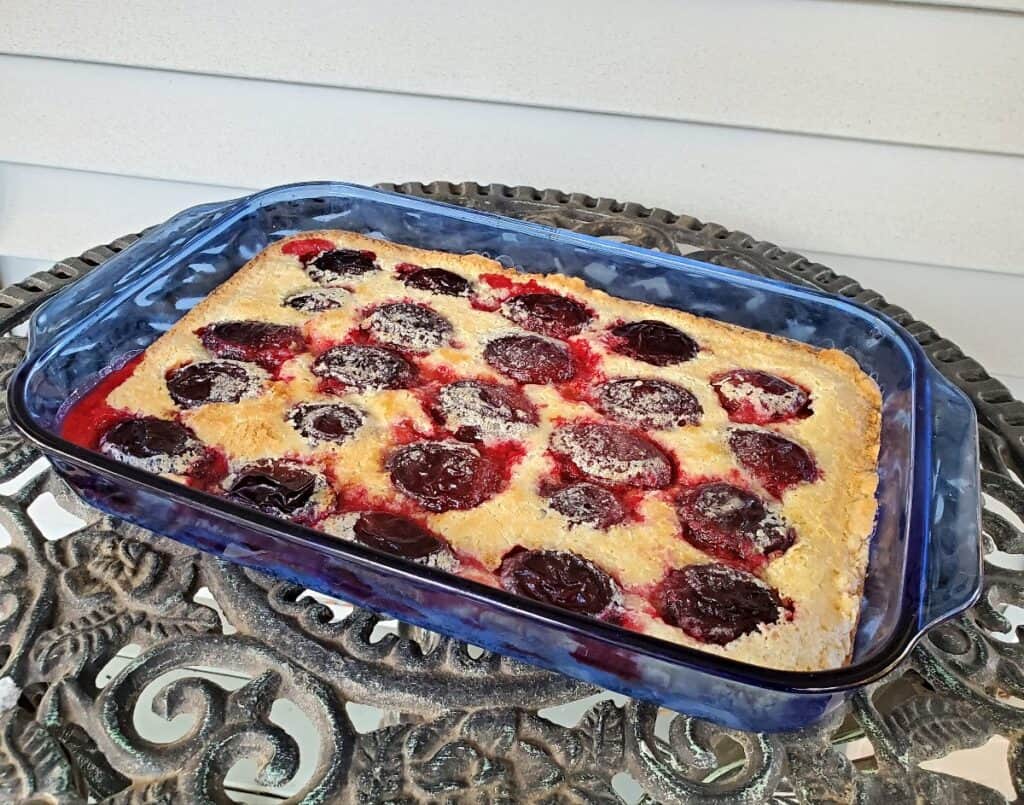 Tray of empress plum kuchen sitting on a wrought iron table.