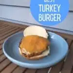 Turkey burger with cheese on a plate on a wooden table with text The best turkey burger.