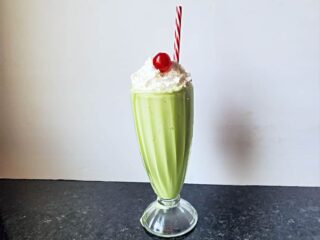 Head on shot of a copycat shamrock shake with whipped cream and a cherry.