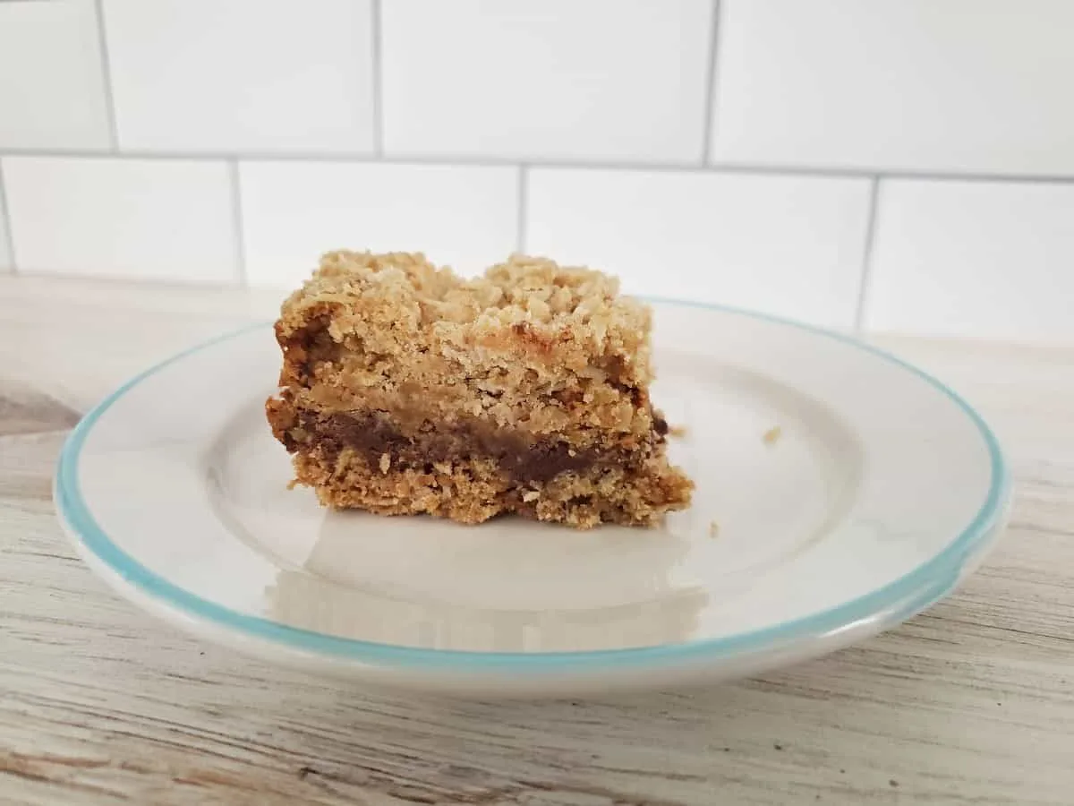 Image shows A piece of chocolate caramel bar on a plate.